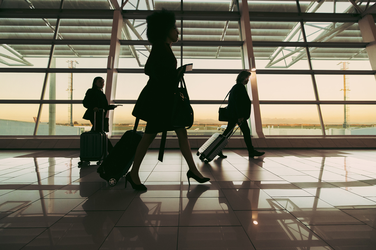 Business travel: Silhouette of people walking at airport terminal