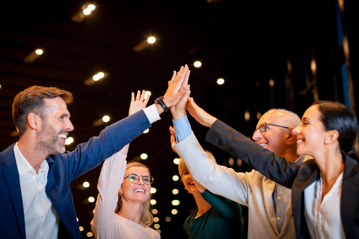 A group of people at a business event doing a group high-five