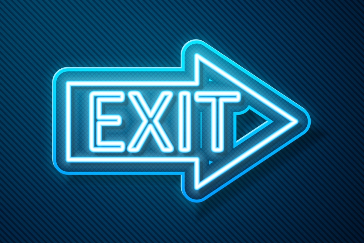 Glowing blue neon exit sign on dark blue background