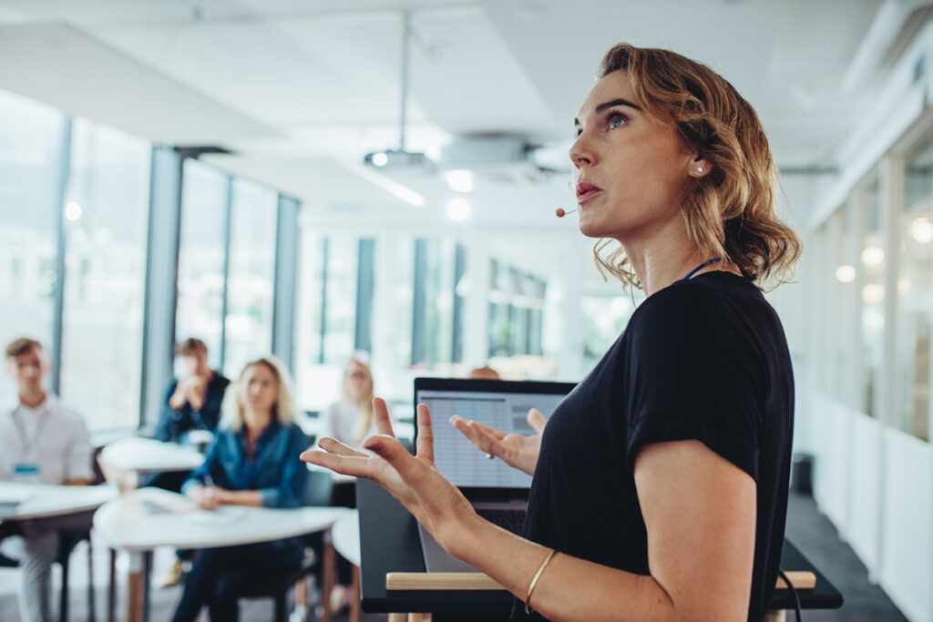 White woman giving a presentation at a small event