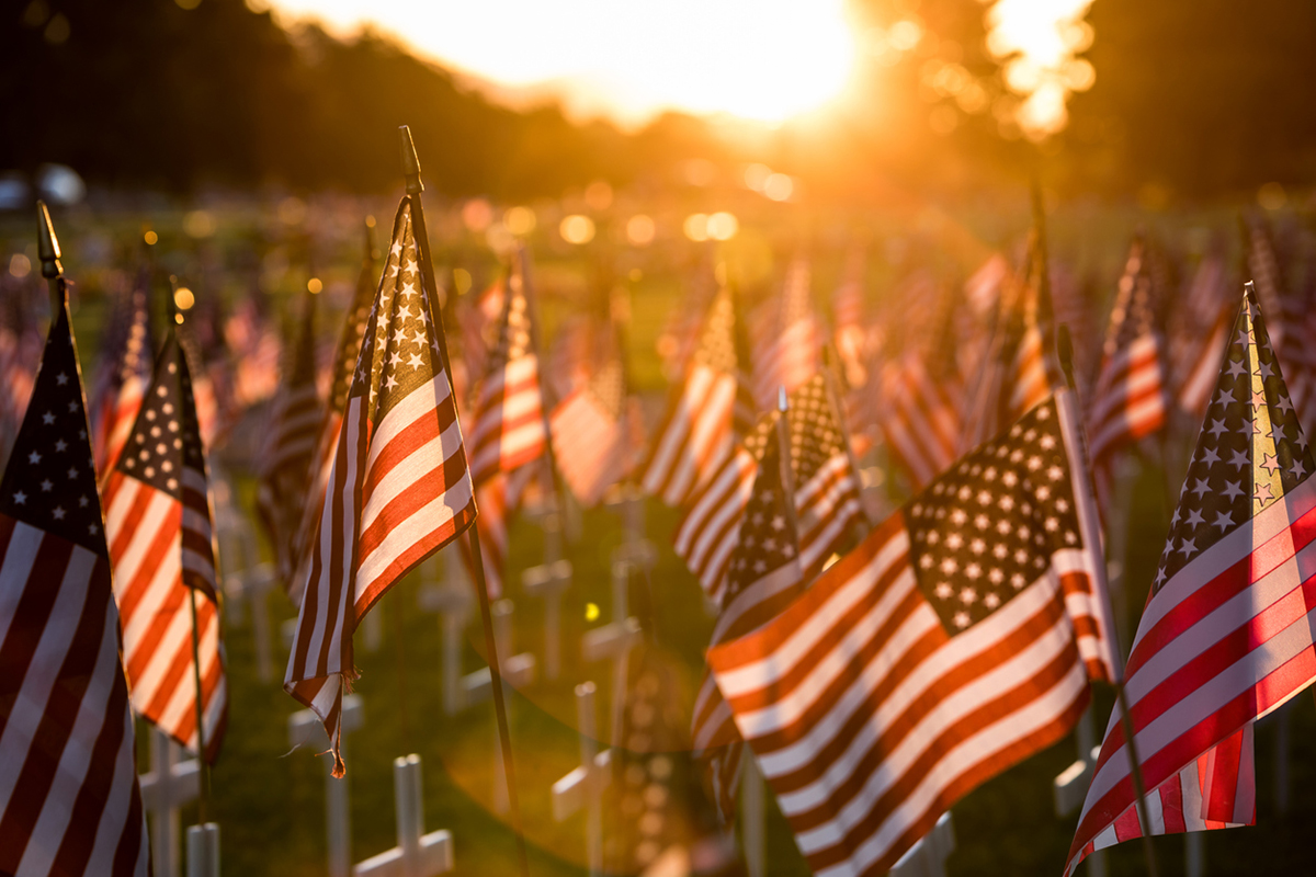 Field of American flags at sunset representing sacrifice of US soldiers