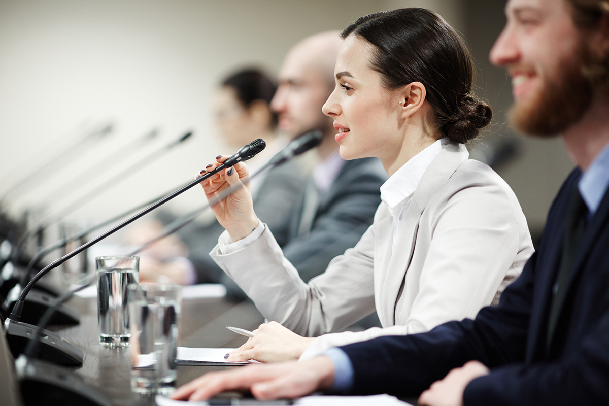 Woman speaking on a discussion panel at a conference