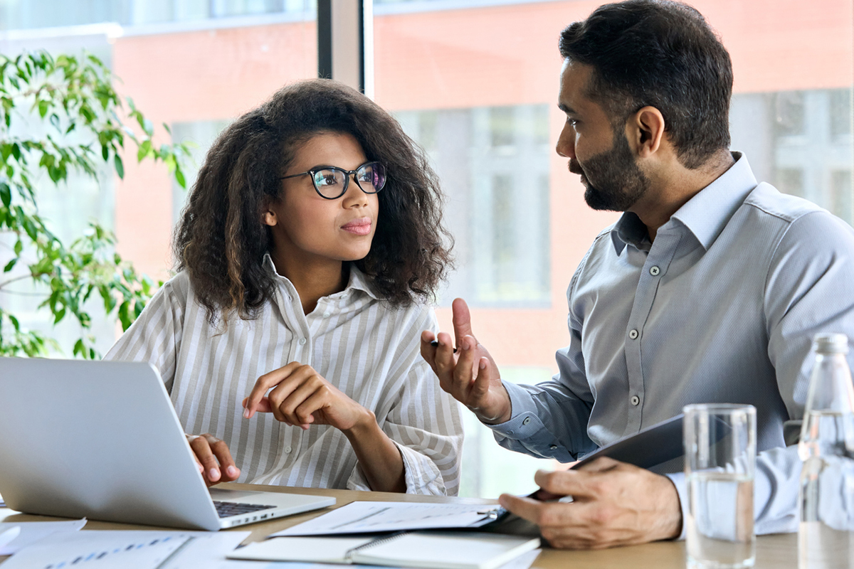 Indian man providing a consultation to a young black woman, offering his expertise