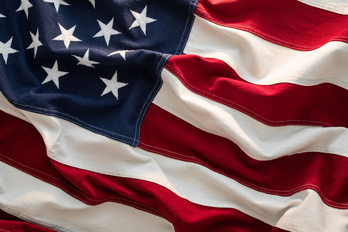 Close-up US Flag American flag waving in sunlight, honoring the meaning of Memorial Day