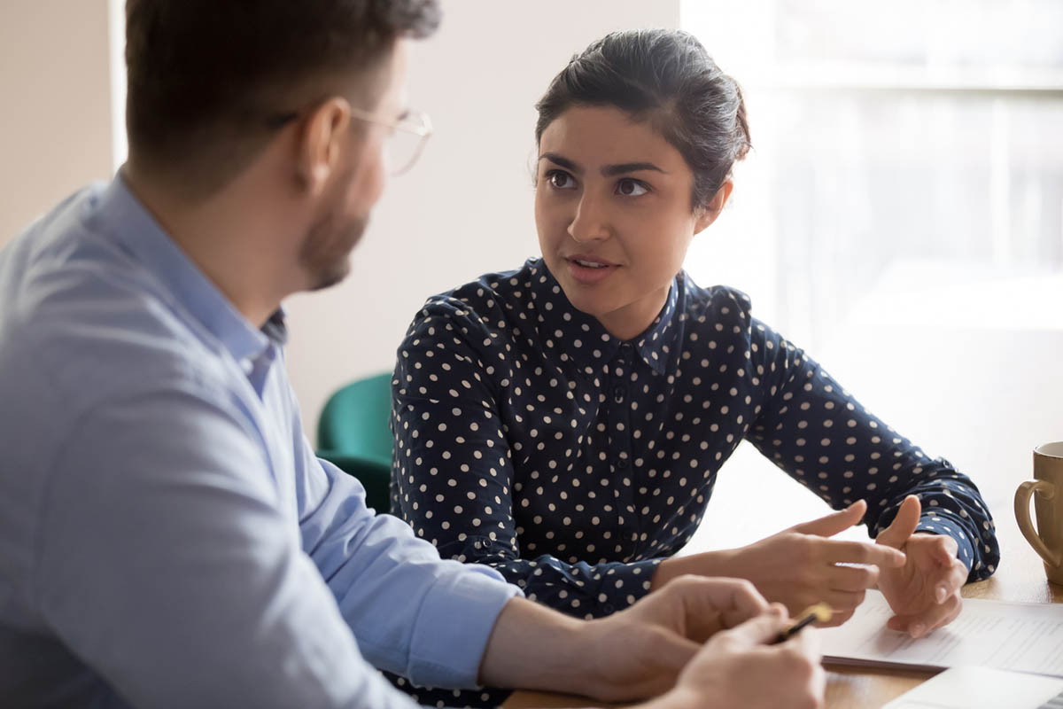 Young Indian woman consults a young white male client about a new idea, with the goal of overcoming resistance to change