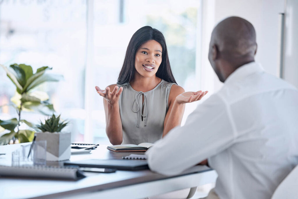 Black woman talking with a black man, illustrating how to give constructive criticism