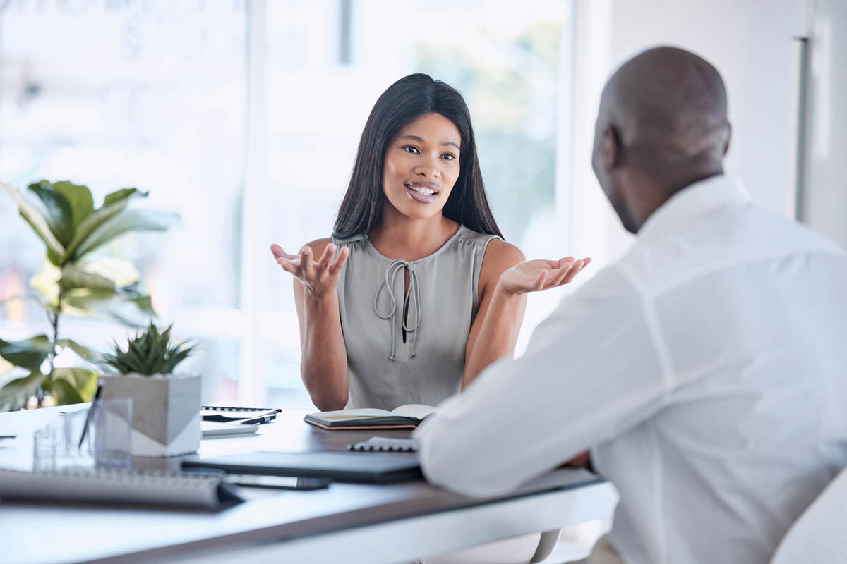 Black woman talking with a black man, illustrating how to give constructive criticism