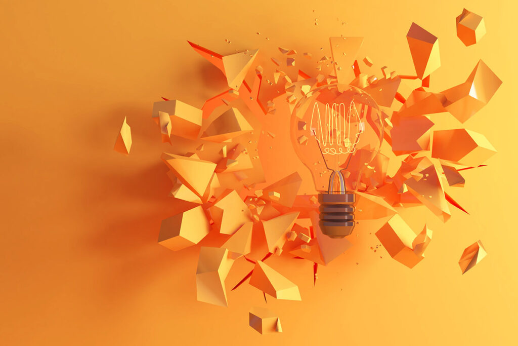 Lightbulb breaking through shattered pieces on an orange background, symbolizing innovation and learning from failure in business.