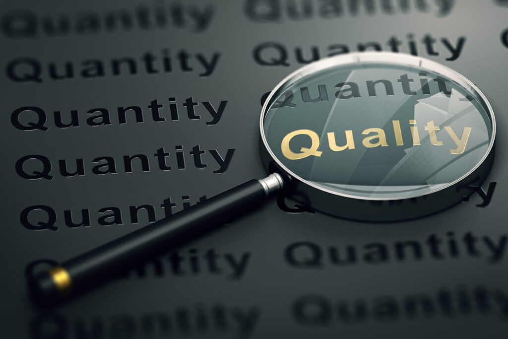 A magnifying glass highlighting the word quality among many instances of the word quantity, illustrating credible, quality content that buyers trust