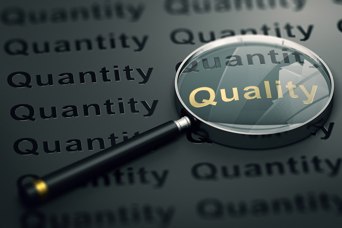A magnifying glass highlighting the word quality among many instances of the word quantity, illustrating credible, quality content that buyers trust