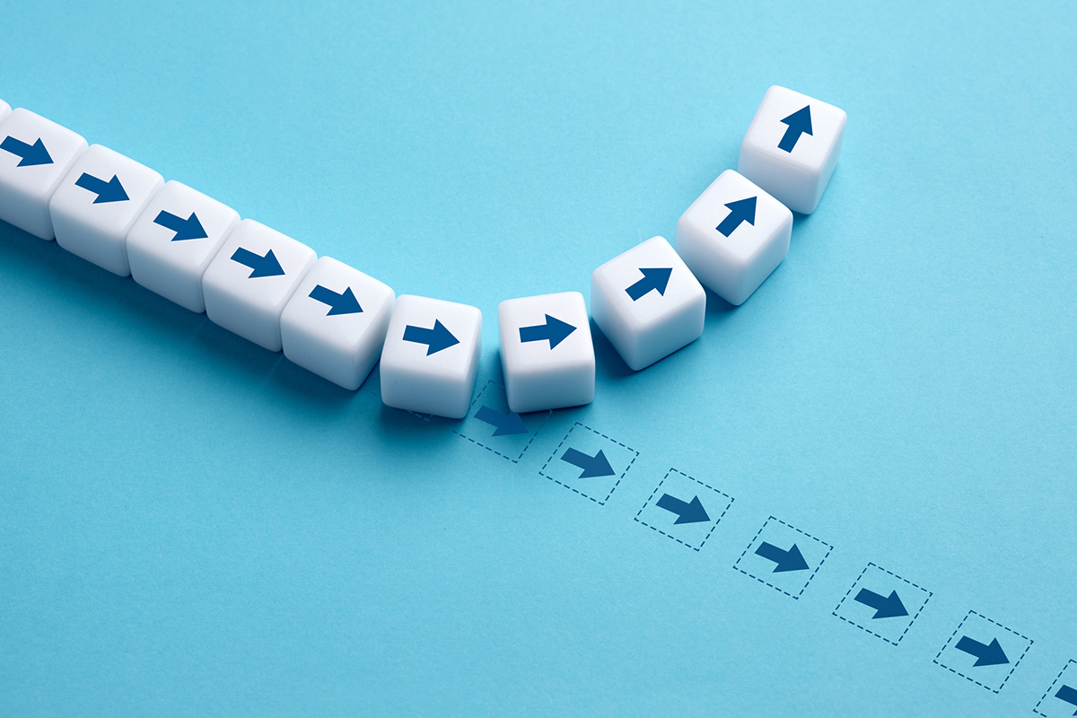 White cubes with arrows change direction in a curved path on a blue background, symbolizing shifting buyer expectations and the need to pivot.