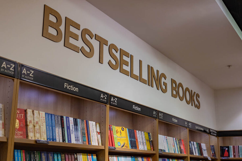 Bookshelves under a large “Bestselling Books” sign in a bookstore, illustrating how bestselling author credibility is often associated with prominent displays.