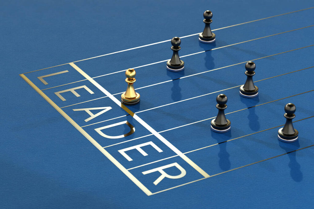 Gold chess piece crossing a finish line labeled “Leader,” symbolizing experiential leadership development and demonstrated expertise.