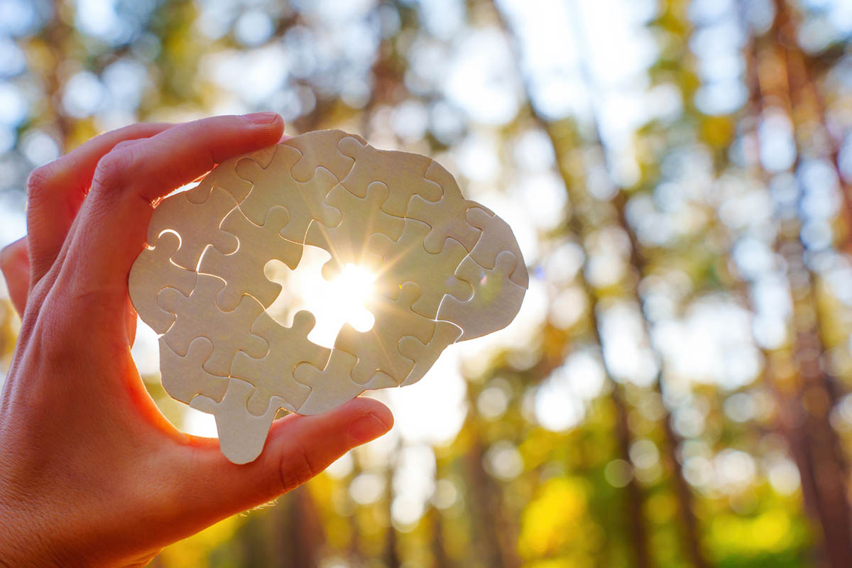 Hand holding a brain-shaped puzzle with one missing piece, symbolizing a how small thoughtful shifts create moments buyers remember and how to stand out in sales.