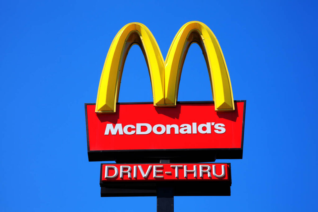 McDonald’s drive-thru sign with golden arches against a bright blue sky, reminding companies of the marketing mistake the company made and the importance of brand authenticity.
