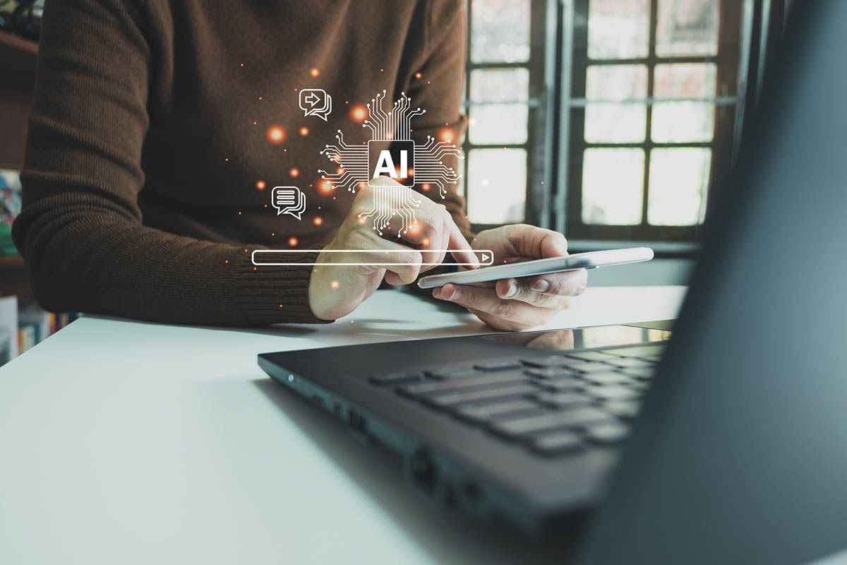 Person using a tablet beside a laptop with digital AI, search, and messaging icons, illustrating how AI visibility influences online discovery and recommendations.